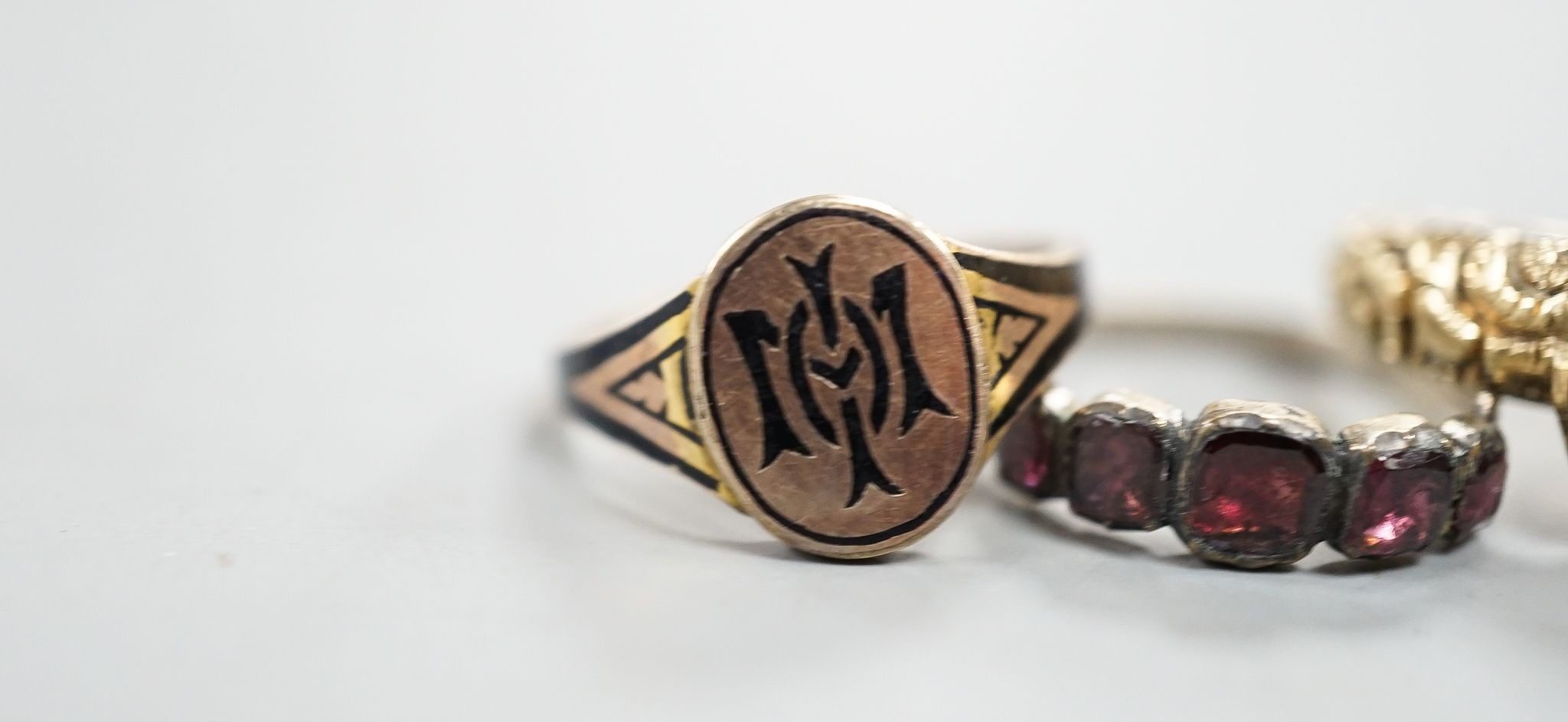 A late George III yellow metal, garnet and plaited hair mounted mourning ring, inscribed 'Ann Haycock Obt. 1 Mar. 1817 at 25, Mary Haycock ob, 26 Mar, 1817 at 15' size N/O, gross 4.6 grams and two other antique rings.